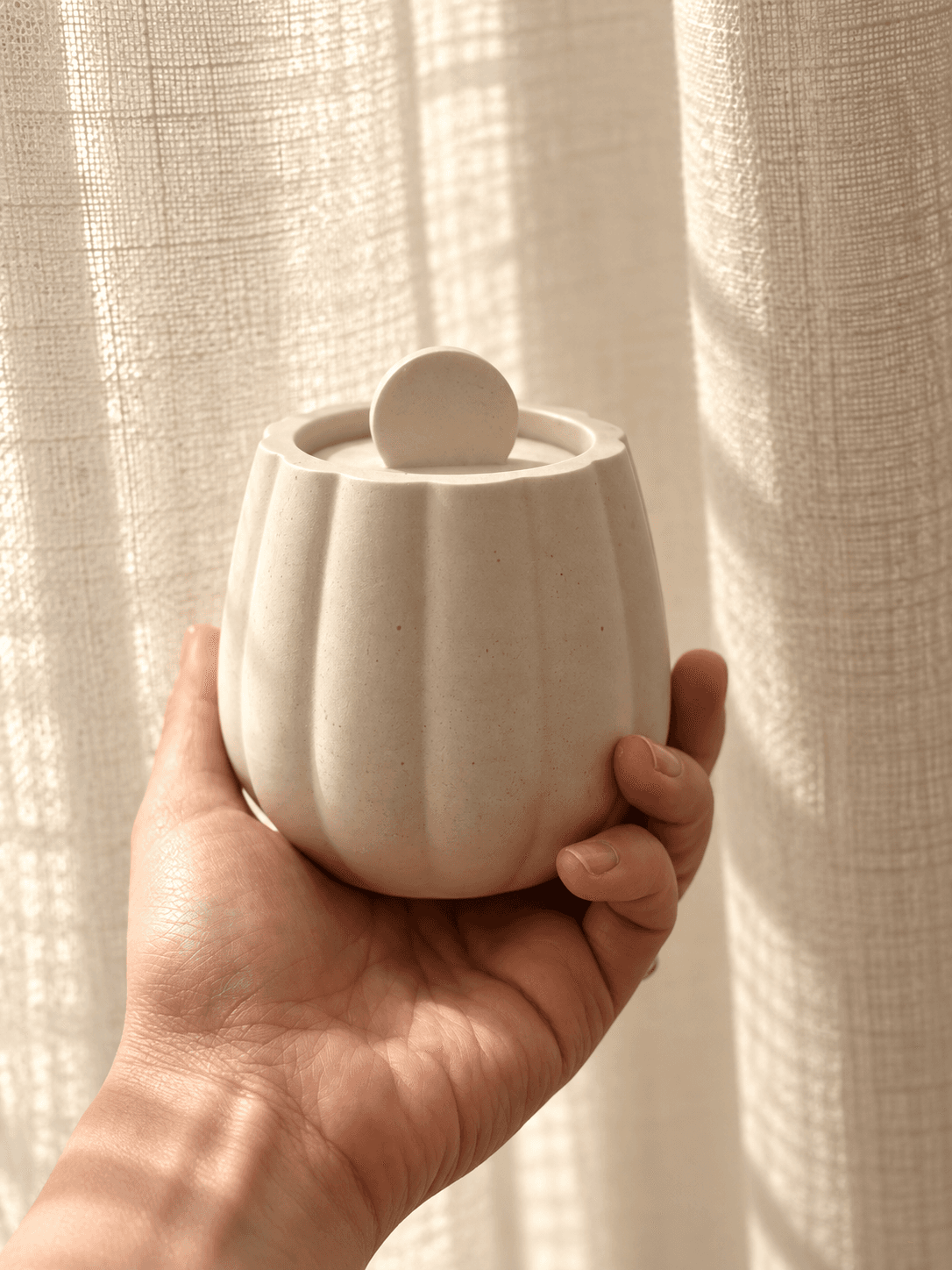 Pot cannelé couvert tenu à la main
